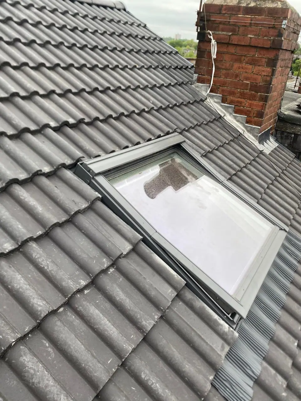 Brick chimney, lead flashing and new tiles around a roof window