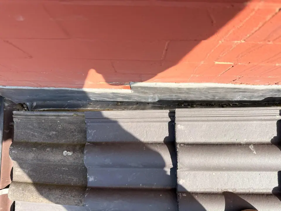 Close view of lead flashing at a wall-to-roof junction