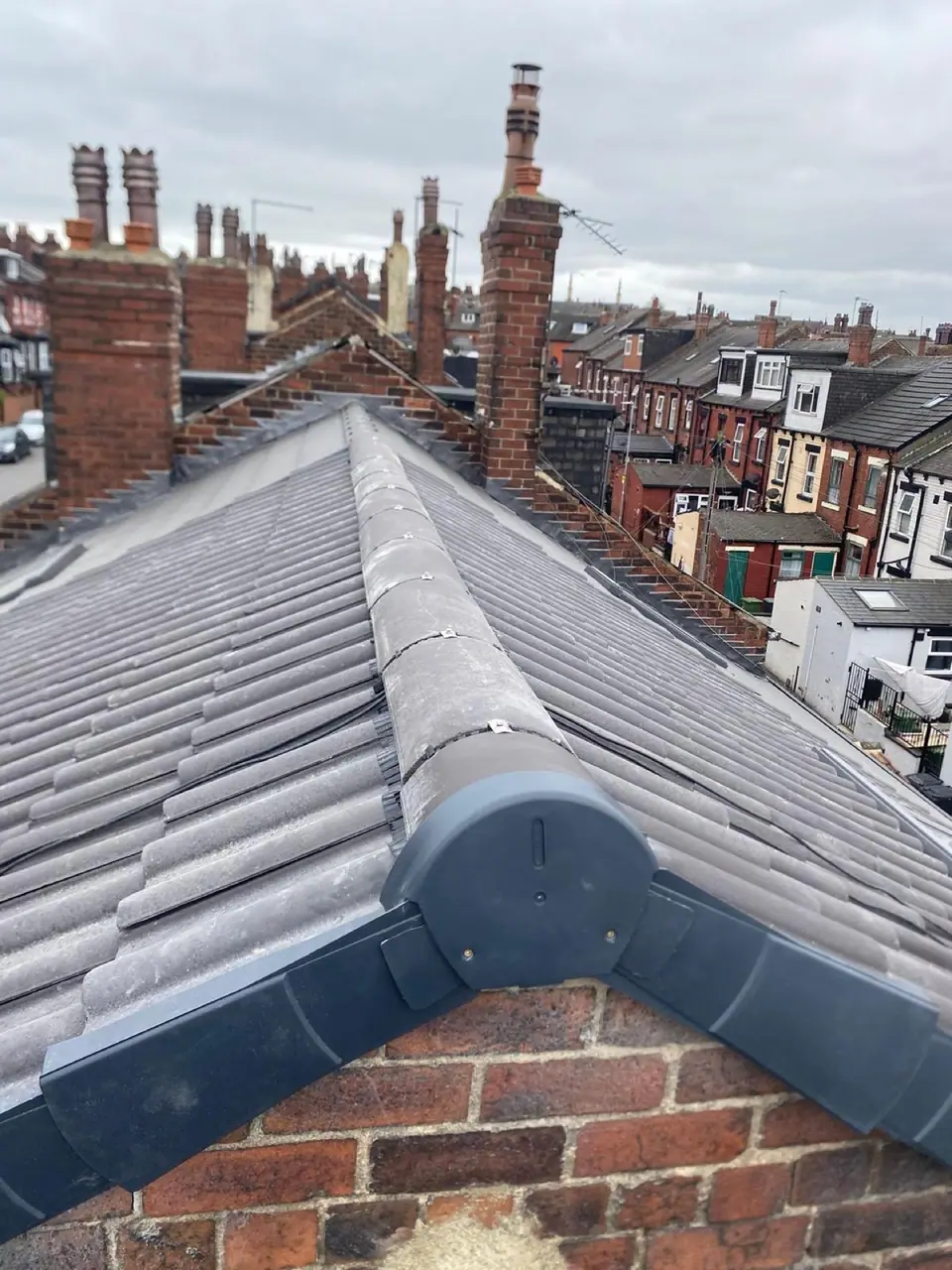 New tiled roof and dry ridge between brick chimney stacks